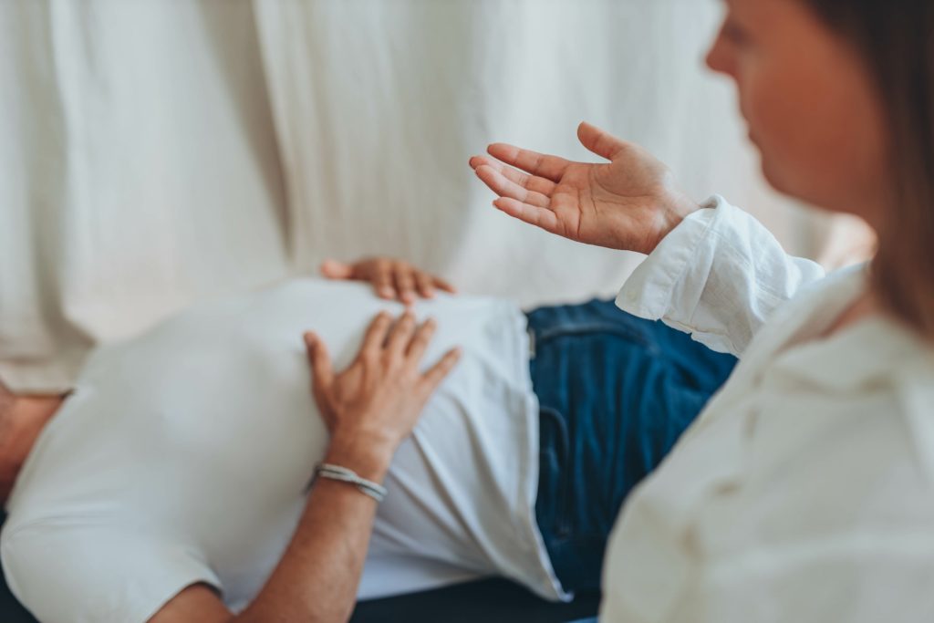 A singer is practicing good breathing  habits lying on the floor. 